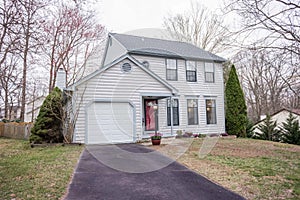 Beautiful two storey white house with trees and a white sky in the background