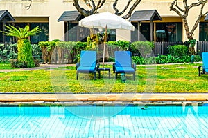 Beautiful umbrella and chair around swimming pool in hotel and resort