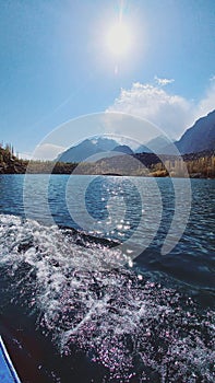 Beautiful upper kachura lake with mountains, trees and blue sky and sunshine properly in Skardu