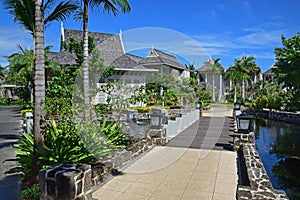 Beautiful upscale resort hotel with small wooden bridge connecting to the villas with abundant trees around