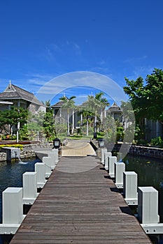 Beautiful upscale resort hotel with small wooden bridge connecting the walkway with the villas