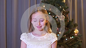 Beautiful upset girl standing near christmas tree and crying indoors