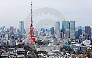 Beautiful urban skyline of Tokyo City under blue sunny sky, with Tokyo Tower standing tall among crowded high-rise skyscrapers