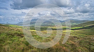 Beautiful valley with green fields, forest and lake, surrounded by hills, Dingle Peninsula