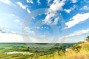 A beautiful valley with a river, blue sky with large clouds and bright sun. Aerial 4K UHD