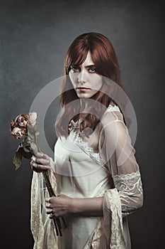 Beautiful vampire woman with dead roses