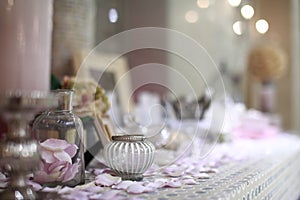 Beautiful vanity with purple flower petals and perfume bottles.