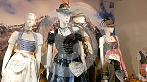 Beautiful various women`s national Bavarian costumes dirndl on shop window