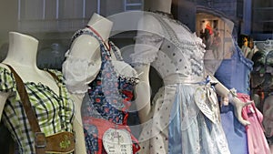 Beautiful various women`s national Bavarian costumes dirndl on shop window