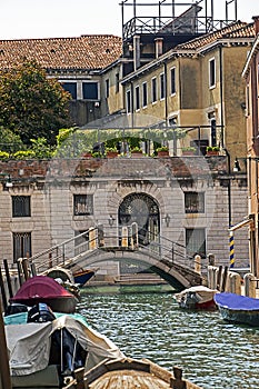beautiful Venetian canal in Venice with gondolas and other public water transport
