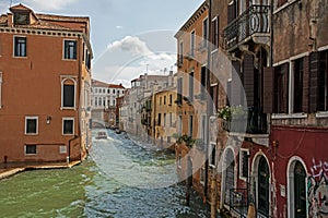 beautiful Venetian canal in Venice with gondolas and other public water transport facilities, highlighting travel