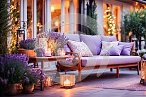 Beautiful veranda at dusk, illuminated by lanterns and candles, with bouquets of lavender and comfortable furniture for relaxing