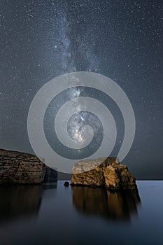 A beautiful vertical Milky Way night sky landscape photograph of Dwejra Bay