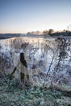 Beautiful vibrant English countryside lake image with frost and