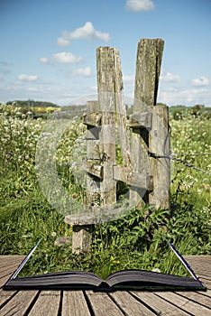 Beautiful vibrant English countryside landscape in idyllic sunshine conditions for hiking concept coming out of pages in open bo