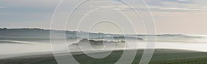 Beautiful vibrant landscape image of sea of fog rolling across South Downs English countryside during Spring sunrise