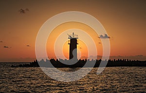 Beautiful Vibrant Sunrise Sky Over Calm Sea Water And Lighthouse