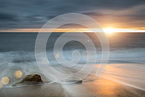 Beautiful vibrant sunset landscape image of Burton Bradstock golden cliffs in Dorest England