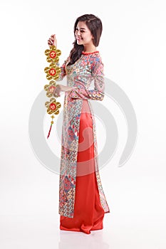 Beautiful Vietnamese woman wearing impression ao dai holding lucky decorate object