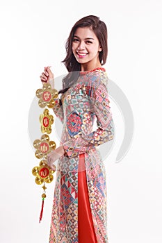 Beautiful Vietnamese woman wearing impression ao dai holding lucky decorate object