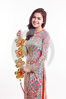 Beautiful Vietnamese woman wearing impression ao dai holding lucky decorate object