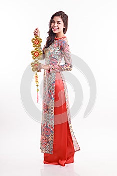 Beautiful Vietnamese woman wearing impression ao dai holding lucky decorate object