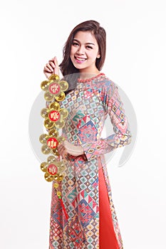 Beautiful Vietnamese woman wearing impression ao dai holding lucky decorate object