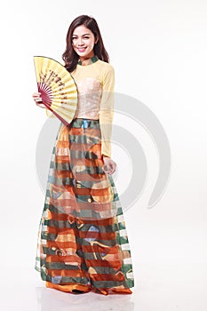 Beautiful Vietnamese young woman with modern style ao dai holding a paper fan on white background