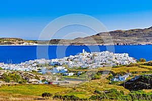 Beautiful view of Adamantas, main town of Milos island, Greece, on sunny day. Hill top town, whitewashed houses, church