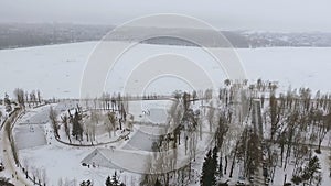 Beautiful view from the air to a winter park and a frozen lake. People relax in the open air, skate, fishermen catch