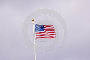 Beautiful view of the American flag waving in the wind against a backdrop of cloudy sky.