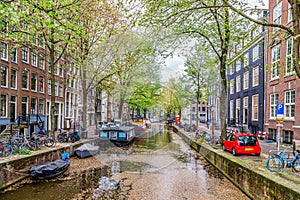 Amsterdam, Netherlands. View of the canal, boats and medieval typical Dutch houses in a spring day.