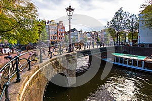 Beautiful view of Amsterdam canals with bridge and typical dutch houses. Holland