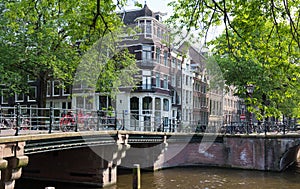 Beautiful view of Amsterdam canals with bridge and typical dutch houses. Holland