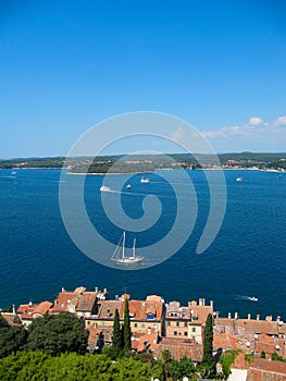 Beautiful view of the ancient city, the island and the sea on which the ship sails. Rovinj, Istria, Croatia. Aerial shot