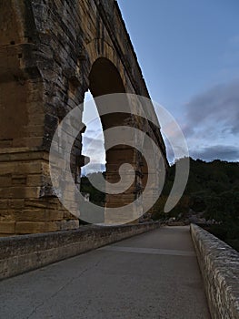 Beautiful view of ancient Roman aqueduct Pont du Gard in the evening near Vers-Pont-du-Gard, Occitanie, France.