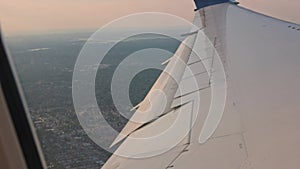 Beautiful view of the Atlantic coastline landscape under the aircraft wing with moving wingtips during the flight