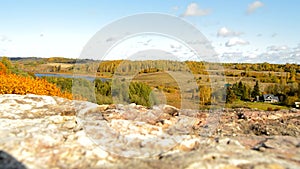 Beautiful view of autumn landscape with yellow trees, hills, lake, meadows and houses, Russia, Pskov, Izborsk