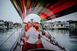 Beautiful view of bangkok canal from wooden long tail boat with colored flowers and amazing light