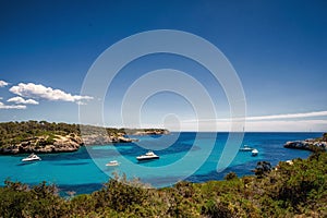 Beautiful view of the bay with turquoise water and yachts in Cala Mondrago National Park on Mallorca island