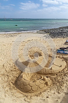 Beautiful view of the beach of Corralejo, Fuerteventura, Canary islands, Spain, with a sand sculpture in the foreground