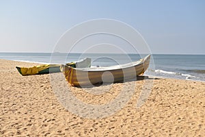 A Beautiful view of a Beach with two Fishing Boats on the Sea Shore on a Sunny Day