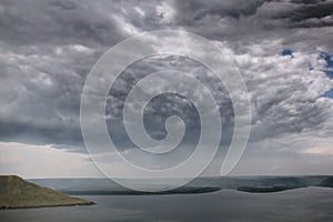 Beautiful view on big lake among hills and rain from clouds. River and cliffs landscape. Bakota lake and Dnister river in Ukraine