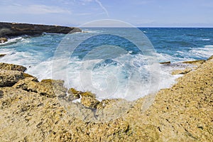 Beautiful view of big waves of Caribbean sea breaking on rocky coast of coast of island of Aruba.