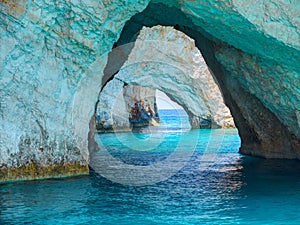 Beautiful view on Blue Caves rock arches from sightseeing boat with tourists in blue water of Ionian Sea inside Blue cave. Island photo