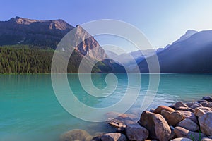 Beautiful view of a blue lake surrounded with high forested mountains on a sunny summer day