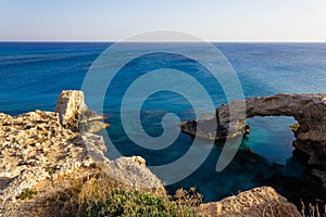 Beautiful view of the blue Mediterranean sea and the rock arch on a Sunny day from Cape Greco in Cyprus. Stone landscape of Ayia