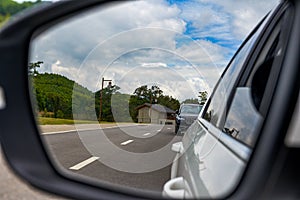 Beautiful view of blue sky and white clouds from car rearview mirror