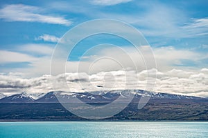 Beautiful view of the bluish Pukaki Lake with snowy Mount Cook in the background, New Zealand