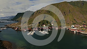 Beautiful view of the boat dock and the red rorbu cabins at the foot of the fjord